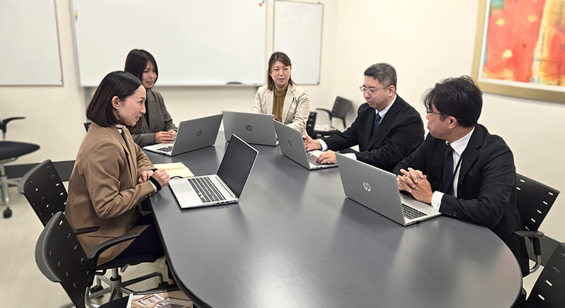 会議室で社員が意見を交わしている様子