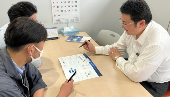 先輩スタッフの研修を受ける男性
