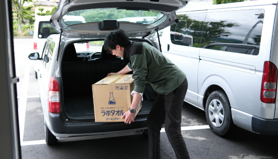 車に商品を積み込む男性