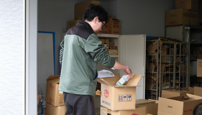 商品を段ボールに入れる男性
